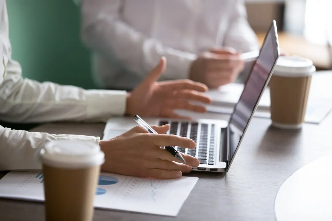 Close-up of a businesswoman using a laptop to present a project report at a business meeting.