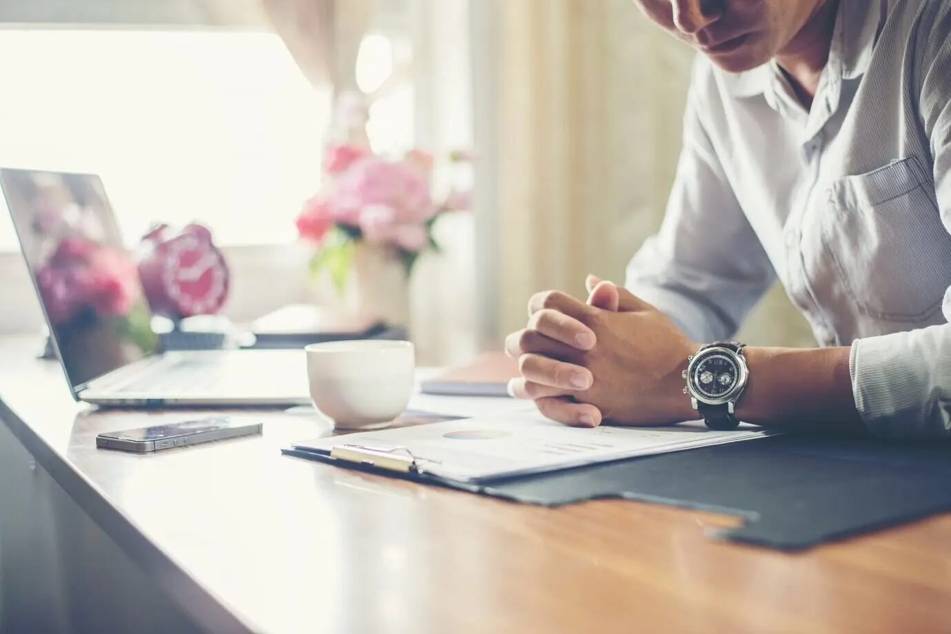 A businessman working at his office desk with a cup of coffee.